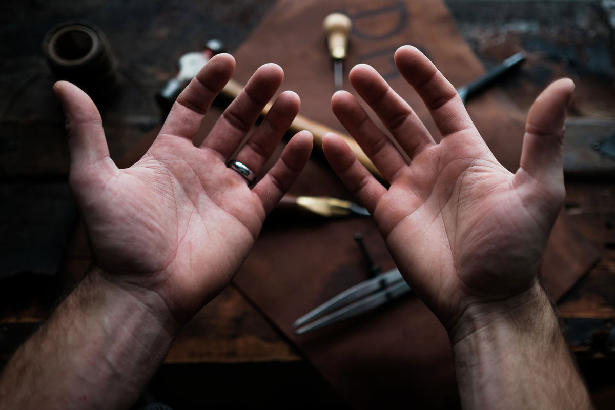 Leatherworker's hands over a workbench, leathercraft PDF patterns